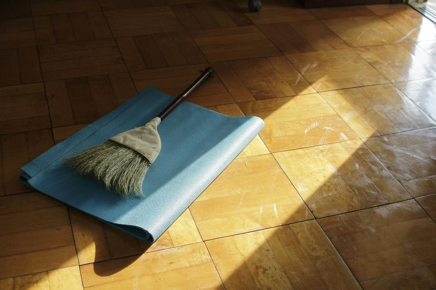 Tapis de sol bleu déroulé sur un parquet baigné de soleil